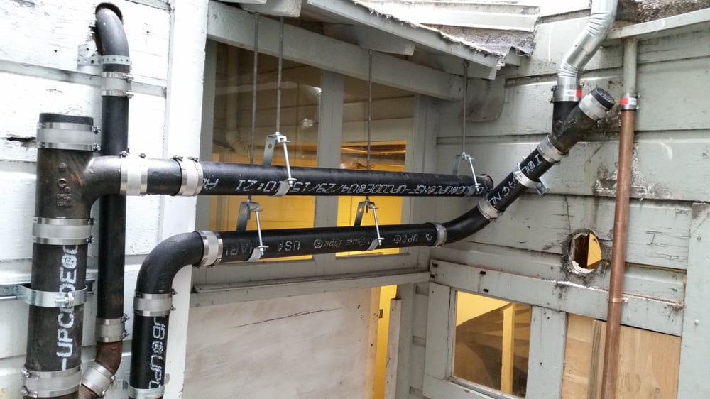 New ABS no-hub sewer and drain piping installed and strapped along exterior framing